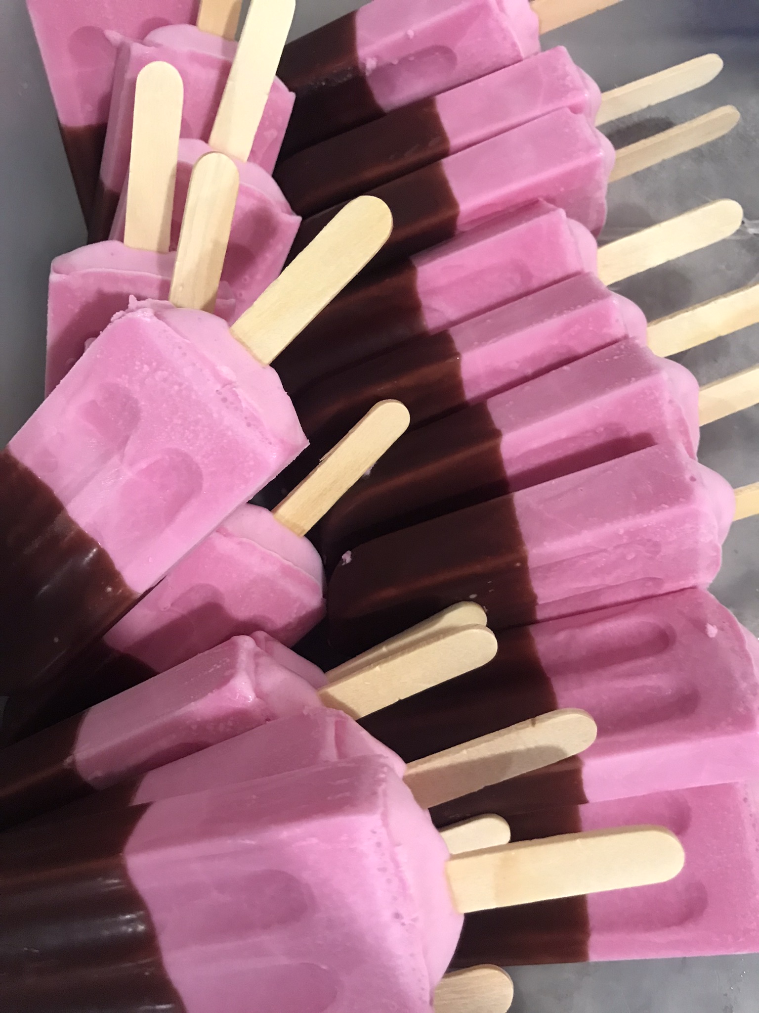 Picolés rosa com cobertura de chocolate